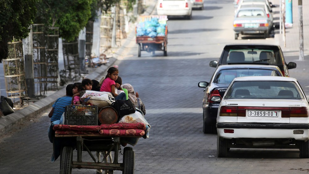 Palestinians flee their homes and head towards a United Nations' school to seek shelter in Gaza City, July 13, 2014.