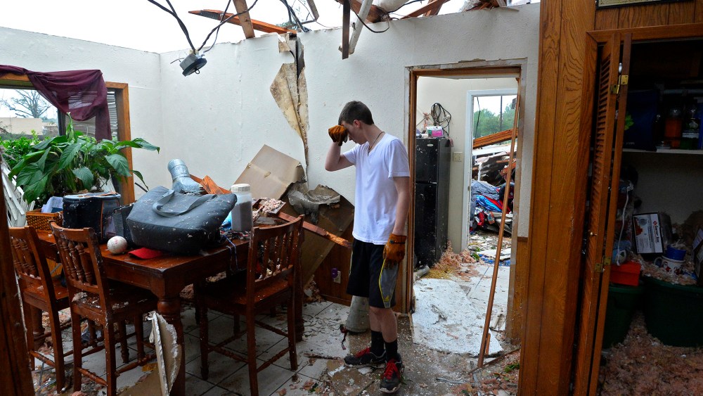 Shelby Van Sickle pauses while trying to salvage personal items in the family home that was destroyed after a tornado touched down overnight in Van, Texas, on May 11, 2015. (Photo by Larry W. Smith/EPA)