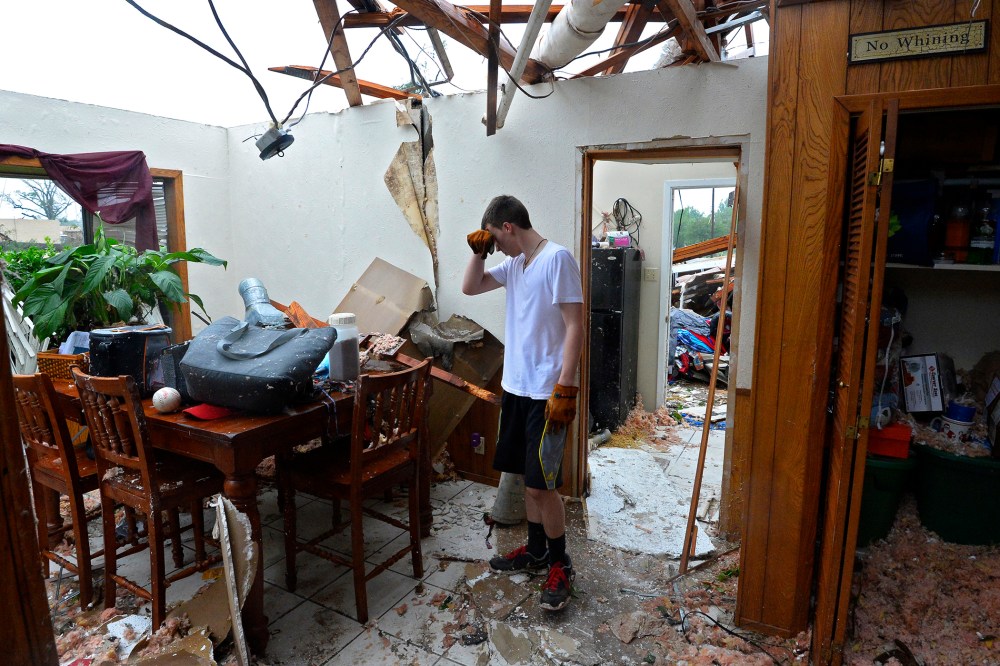 Shelby Van Sickle pauses while trying to salvage personal items in the family home that was destroyed after a tornado touched down overnight in Van, Texas, on May 11, 2015. (Photo by Larry W. Smith/EPA)