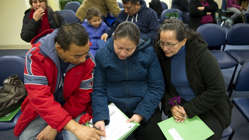 Jasmine Contreras, center, her husband Henry Valerio, left, and mother, Avida Flores, all from Dumfries, Va., fill-out a health care insurance application in Manassas, Va., on Nov. 15, 2014.