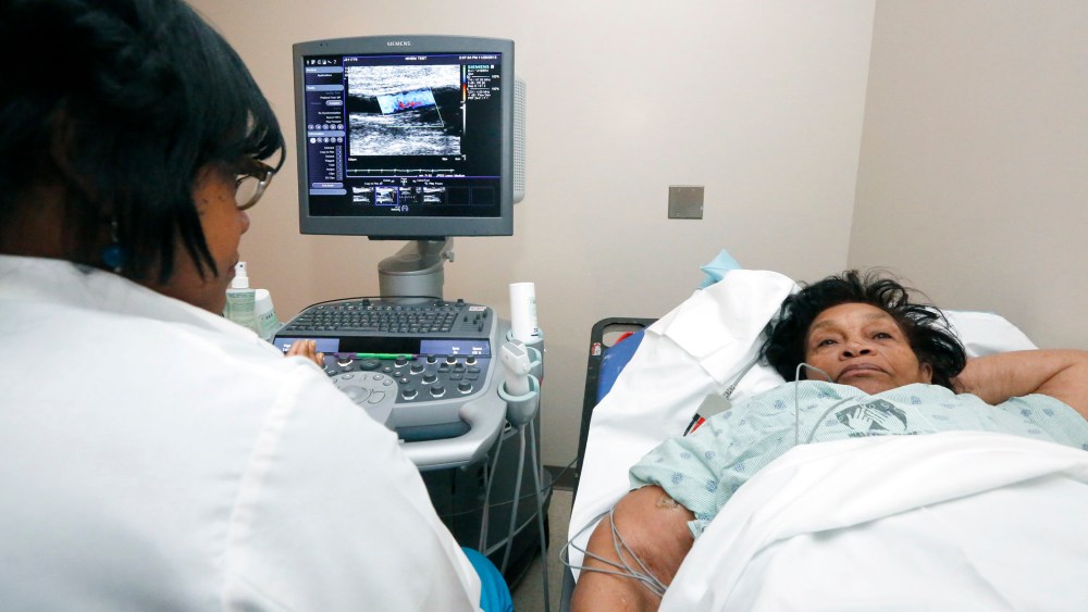 In this Nov. 25, 2013 photograph, Alberta Epps of Jackson, Miss., right, undergoes a sonogram of the brachial artery.
