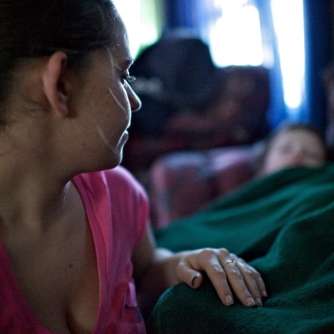 Alicia, a mother in Johnstown, Pa., tucks her two sons after returning home from working the night shift at a senior citizen home.  Alicia has two young boys and her boyfriend does not work, making her the sole provider for her family.