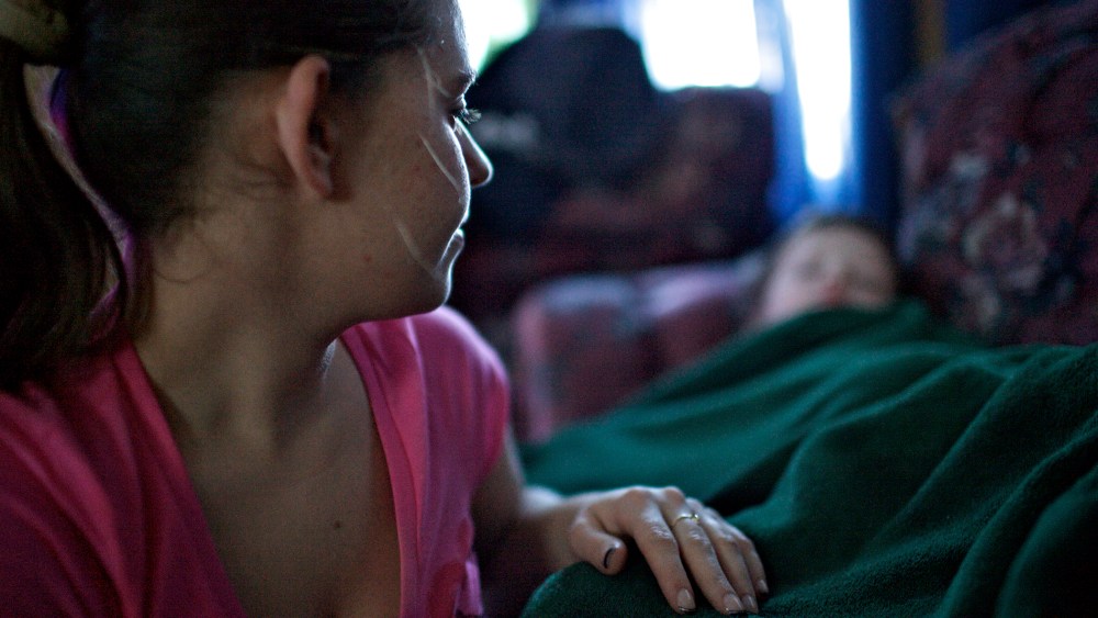 Alicia, a mother in Johnstown, Pa., tucks her two sons after returning home from working the night shift at a senior citizen home.  Alicia has two young boys and her boyfriend does not work, making her the sole provider for her family.