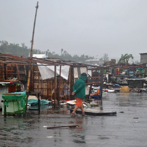 A man walks past destroyed houses in Tacloban, central Philippines, on Dec. 7, 2014 after Typhoon Hagupit. (Lito Bagunas/AFP/Getty)