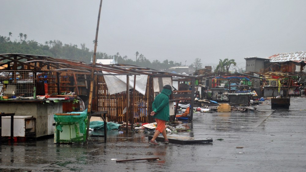 A man walks past destroyed houses in Tacloban, central Philippines, on Dec. 7, 2014 after Typhoon Hagupit. (Lito Bagunas/AFP/Getty)