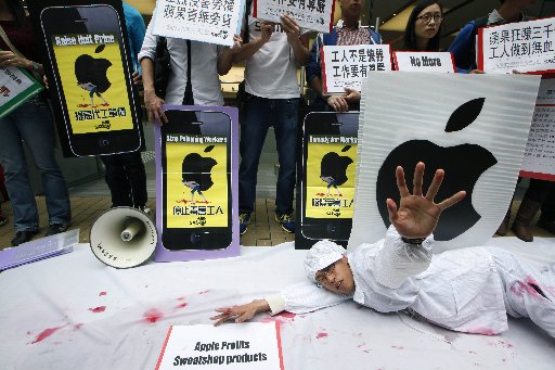 Local university students and labor rights activists carry mock iPhones during a protest outside an Apple store in Hong Kong Tuesday, Feb. 26, 2013. The protesters were demonstrating against allegedly harsh labor practices facing workers who are...