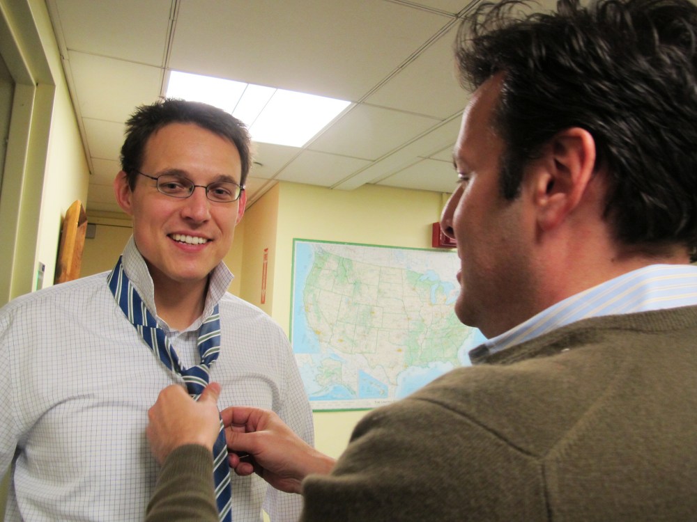 Bill Wolff, executive producer for The Rachel Maddow Show, helps Steve Kornacki tie his necktie before guest hosting, December 18, 2013.