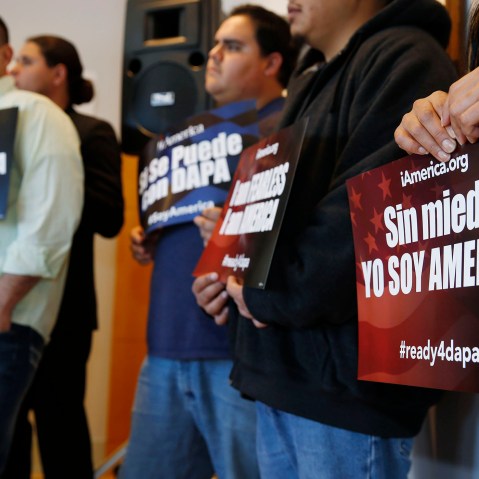 Supporters hold placards in support of immigration law changes during a news conference in the Denver Public Library, on Feb. 17, 2015, in Denver.