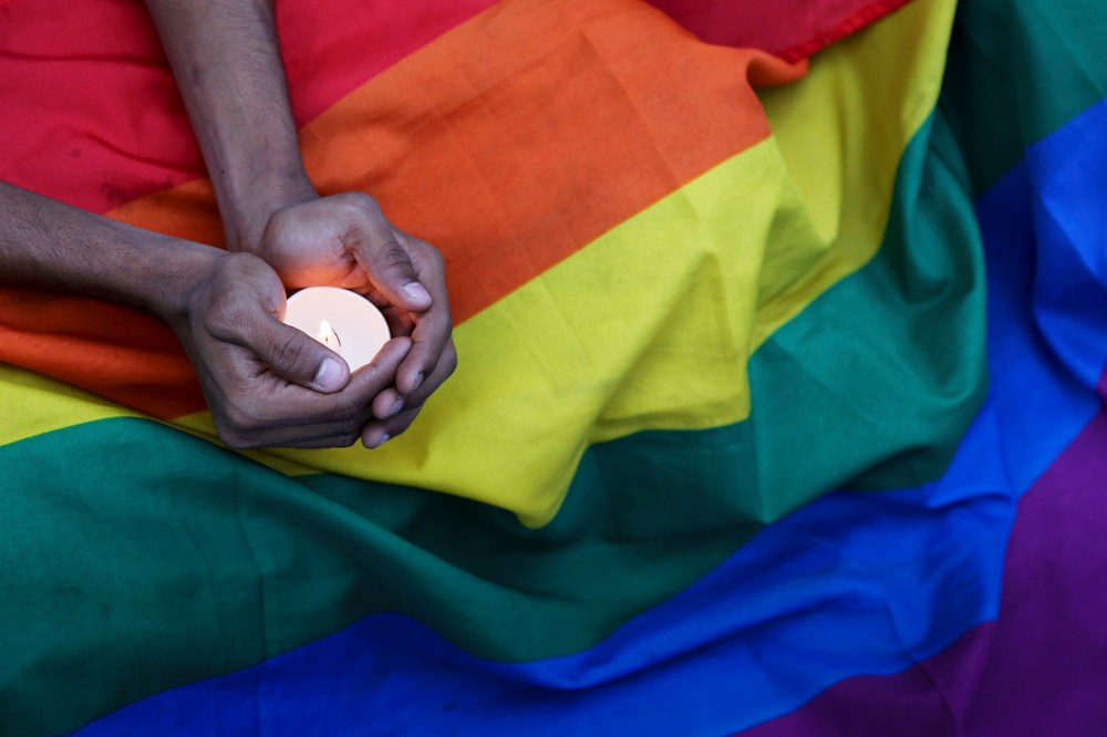 A participant holds a candle during a candlelight vigil condemning the mass shooting at the Pulse nightclub in Orlando, Fla. as they gather in Bangalore, India on June 14, 2016. (Photo by Aijaz Rahi/AP)