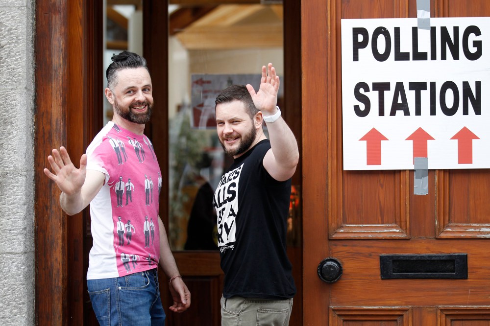 Partners Adrian, left and Shane, arrive to vote at a polling station in Drogheda, Ireland, Friday, May 22, 2015. (Photo by Peter Morrison/AP)