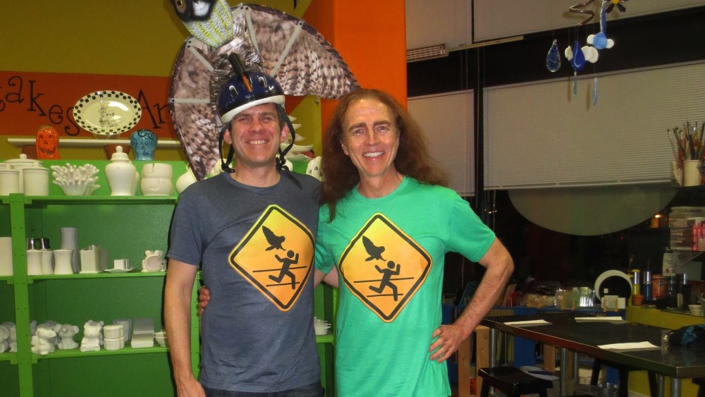 Dr. Ron Jaecks, owl attack-surviving jogger, poses with a homemade owl warning sign t-shirt.
