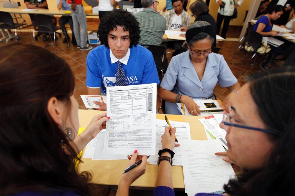 Immigrants Daniel Nino, left, with his mother Patricia Cara from Colombia, get help with documents and filling with the Deferred Action Childhood Arrivals applications at Casa de Maryland in Langley Park, Md., on Wednesday Aug. 15, 2012.
