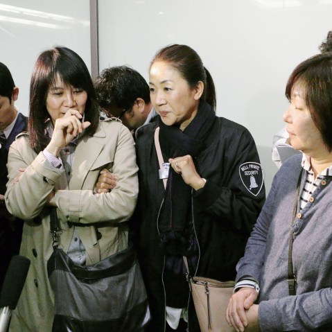 Passengers who escaped from an Asiana Airlines plane that skidded off a runway after landing at Hiroshima Airport speak to the media at the airport in Mihara, Hiroshima Prefecture, western Japan on April 14, 2015.