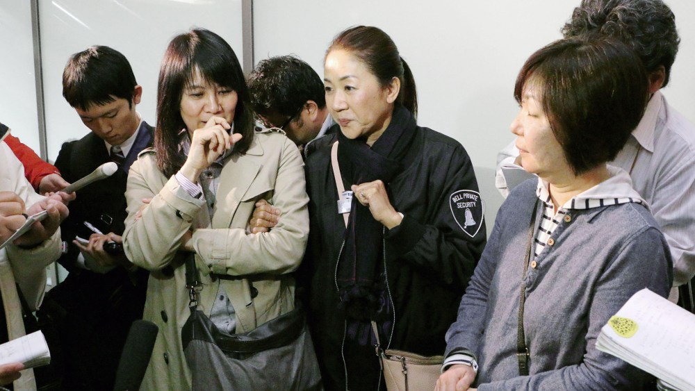 Passengers who escaped from an Asiana Airlines plane that skidded off a runway after landing at Hiroshima Airport speak to the media at the airport in Mihara, Hiroshima Prefecture, western Japan on April 14, 2015.