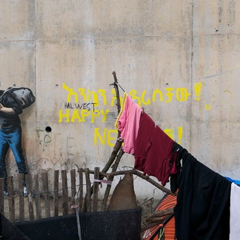 A Banksy mural in a refugee camp in Calais, France, depicts Steve Jobs. (Photo by Banksy)