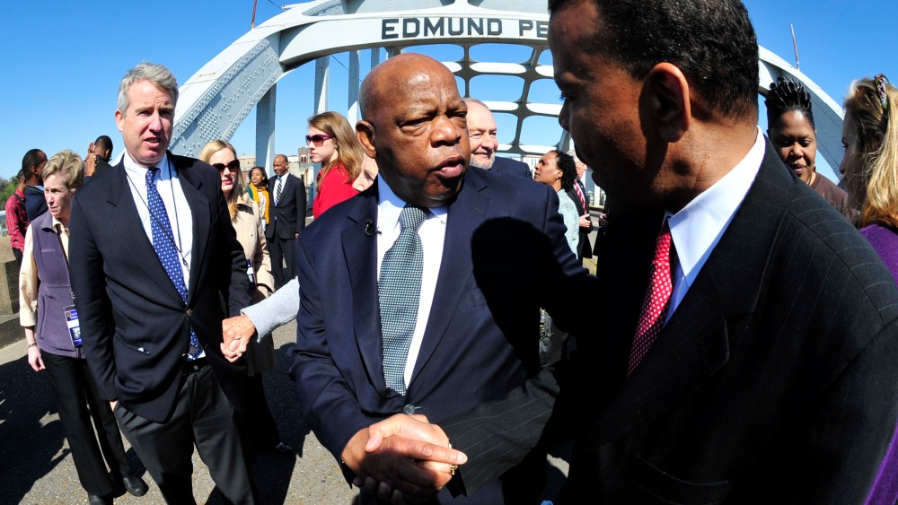 U.S. Rep. John Lewis, D-Ga., center, is greeted by a well wisher as he pauses for a photo opportunity with members of the the Kennedy family prior to commemorating the 47th anniversary of the "Bloody Sunday" civil rights march from Selma to Montgomery...