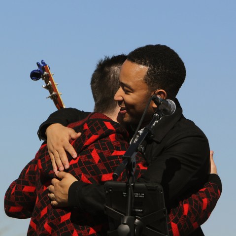 John Legend, front, and Colombian rock star Juanes hug each other after performing in front of a detention center in Eloy, Arizona, Jan. 20, 2016. (Photo by Ricardo Arduengo/AP)