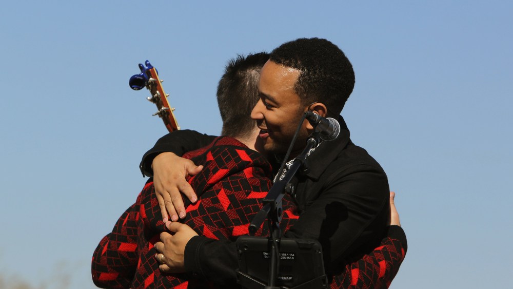 John Legend, front, and Colombian rock star Juanes hug each other after performing in front of a detention center in Eloy, Arizona, Jan. 20, 2016. (Photo by Ricardo Arduengo/AP)