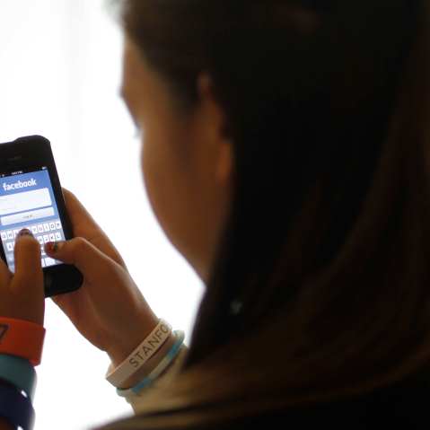 An unidentified 11-year-old girl logs into Facebook on her iPhone at her home in Palo Alto, Calif. in 2012. (AP Photo/Paul Sakuma)