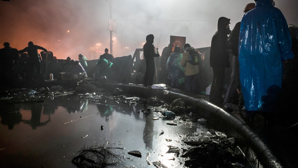 Anti-government demonstrators stand behind a barricade near Kiev's Independence Square on Feb. 19, 2014.