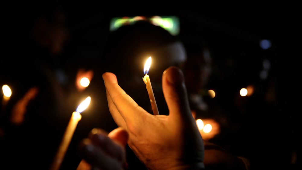 People take part in a candlelight vigil on March 12, 2015, in Ferguson, Mo.