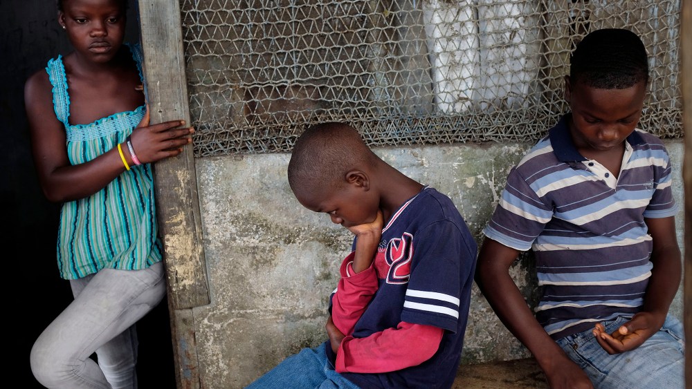 Promise, 16, Emmanuel Junior, 11, and Benson, 15, Cooper sit at their St. Paul Bridge home in Monrovia, Liberia on Sept. 28, 2014. (Jerome Delay/AP)