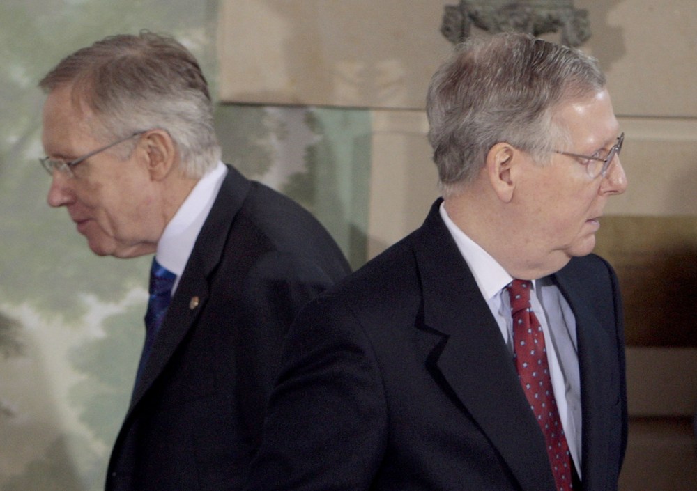 Senate Majority Leader Harry Reid of Nev., left, walks past Senate Minority Leader Mitch McConnell of Ky.  (Photo by Pablo Martinez Monsivais/AP)