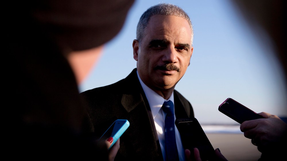 Then, Attorney General Eric Holder talks with media as he arrives on Air Force One in Andrews Air Force Base, Md., on March 6, 2015. (Photo by Carolyn Kaster/AP)