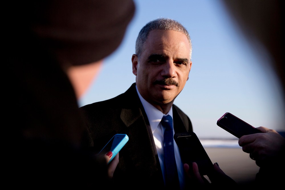 Then, Attorney General Eric Holder talks with media as he arrives on Air Force One in Andrews Air Force Base, Md., on March 6, 2015. (Photo by Carolyn Kaster/AP)