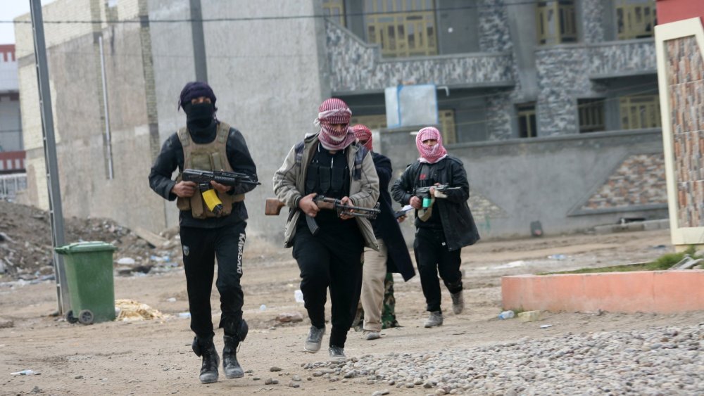 Gunmen patrol during clashes with Iraqi security forces in Fallujah, Iraq,  Jan. 5, 2014.