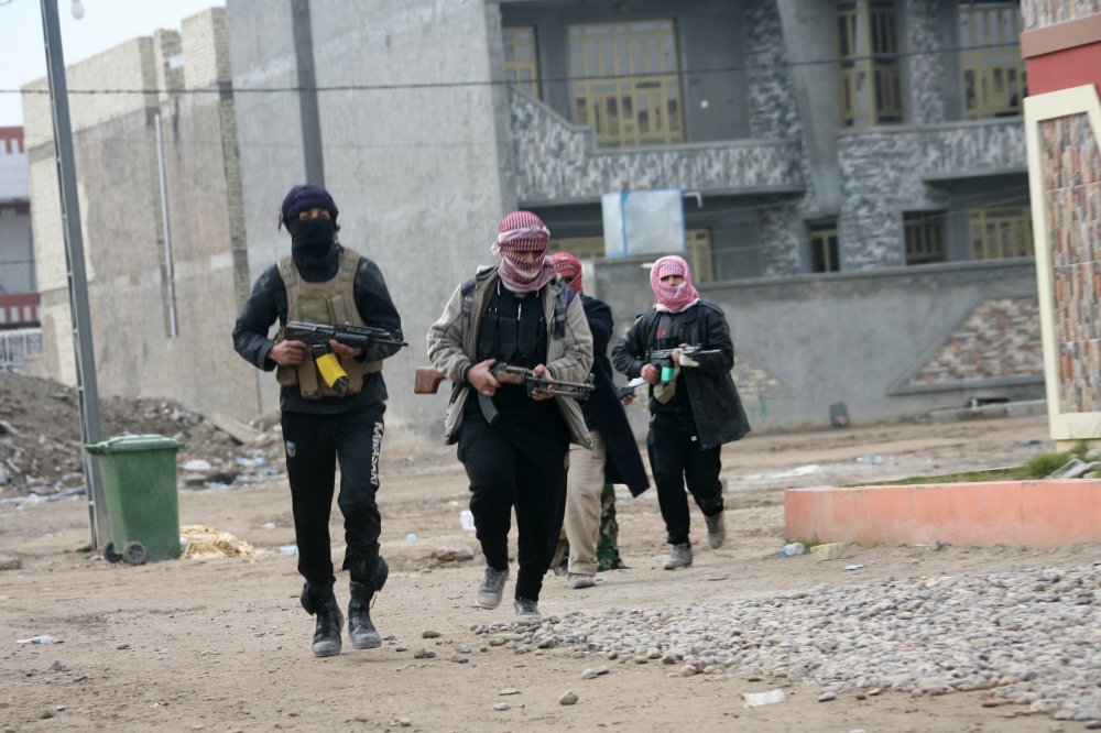Gunmen patrol during clashes with Iraqi security forces in Fallujah, Iraq,  Jan. 5, 2014.