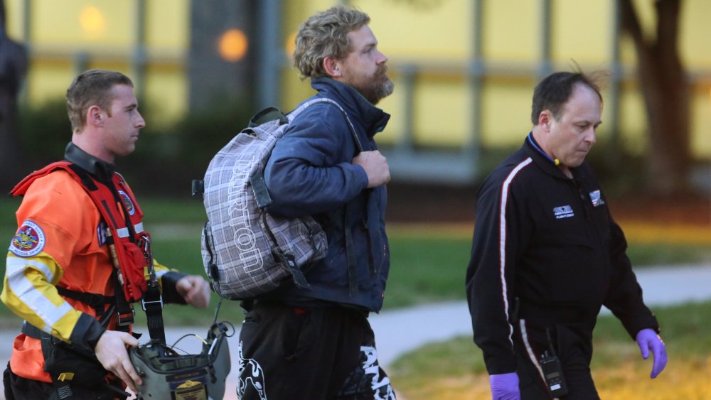 Louis Jordan, center, walks from the Coast Guard helicopter to the Sentara Norfolk General Hospital in Norfolk, Va., after being found off the North Carolina coast, on April 2, 2015. (Photo by Steve Earley/The Virginian-Pilot/AP)