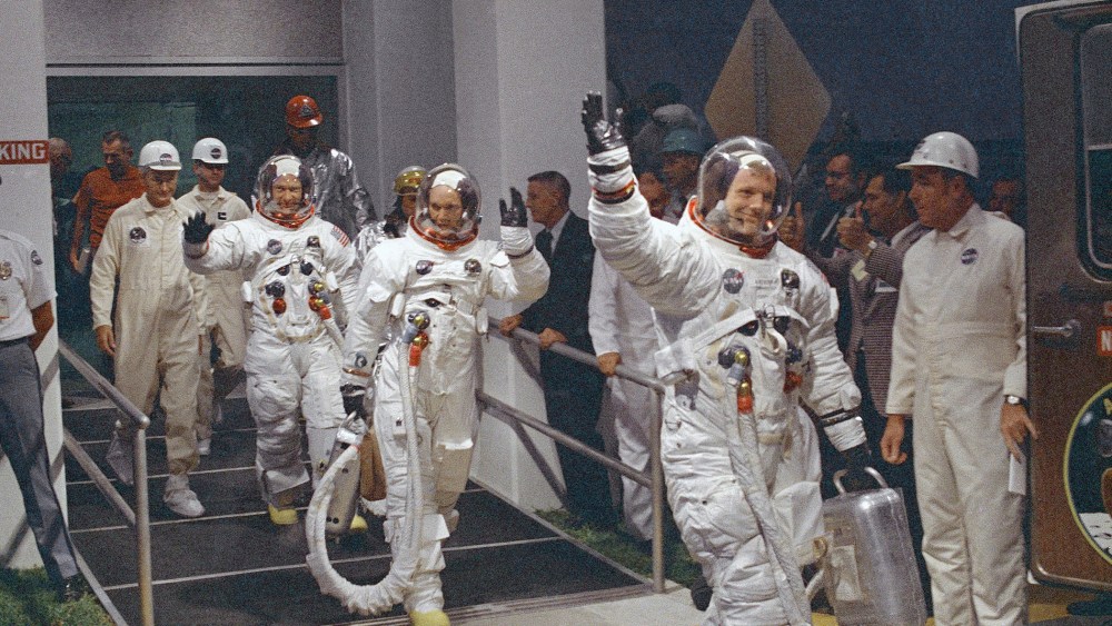In this July 16, 1969 file photo, Neil Armstrong waving in front, heads for the van that will take the crew to the rocket for launch to the moon at Kennedy Space Center in Merritt Island, Fla. (Photo by AP)