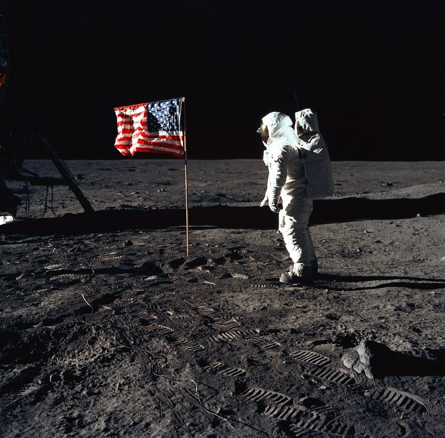 Astronaut Edwin E. Aldrin, Jr., the lunar module pilot of the first lunar landing mission, stands next to a United States flag July 20, 1969 during an Apollo 11 Extravehicular Activity (EVA) on the surface of the Moon.