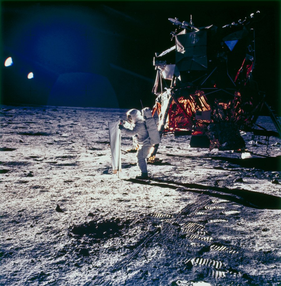 Aldrin is deploys the solar wind experiment on the lunar surface. The lunar module is in the background.