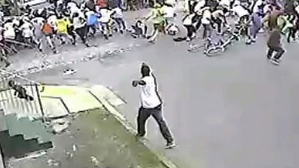 In this image taken from video and provided Monday, May 13, 2013, by the New Orleans Police Department, a possible shooting suspect in a white shirt, bottom center, shoots into a crowd of people, Sunday in New Orleans. (AP Photo/New Orleans Police...