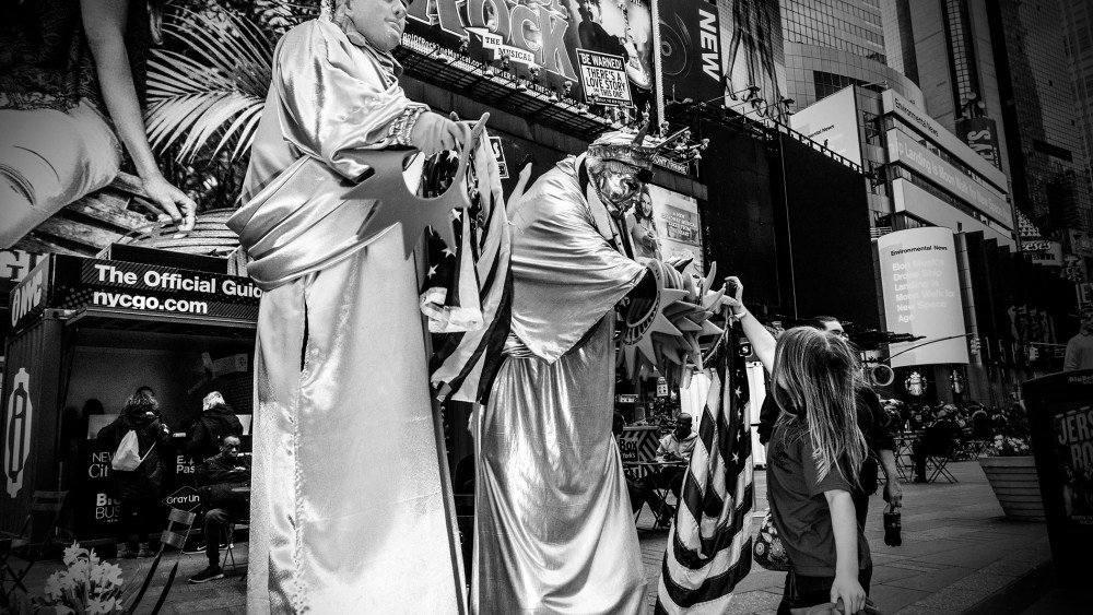 A young girl takes a souvenir from a Statue of Liberty character in Times Square, New York City, April 17, 2016. (Photo by Mark Peterson/Redux for MSNBC)
