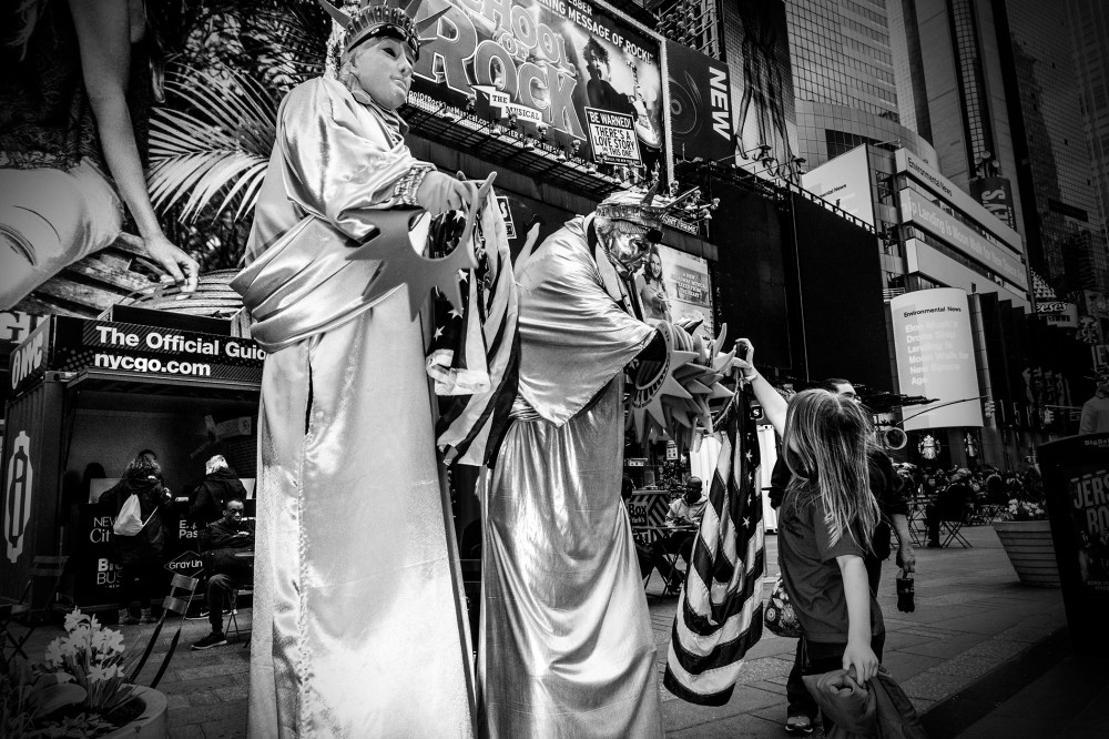 A young girl takes a souvenir from a Statue of Liberty character in Times Square, New York City, April 17, 2016. (Photo by Mark Peterson/Redux for MSNBC)