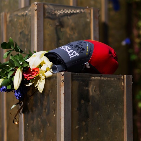 Flowers and a boxing glove are left at a makeshift memorial to Muhammad Ali at the Muhammad Ali Center, June 6, 2016, in Louisville, Ky. (Photo by David Goldman/AP)