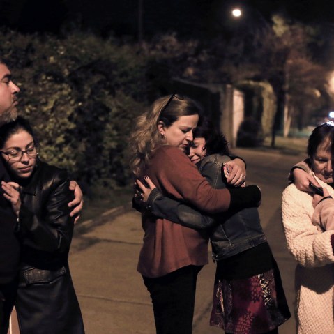 People remain in the street during a strong quake in Santiago on Sept. 16, 2015. (Photo by Alejandro Ruston/AFP/Getty)
