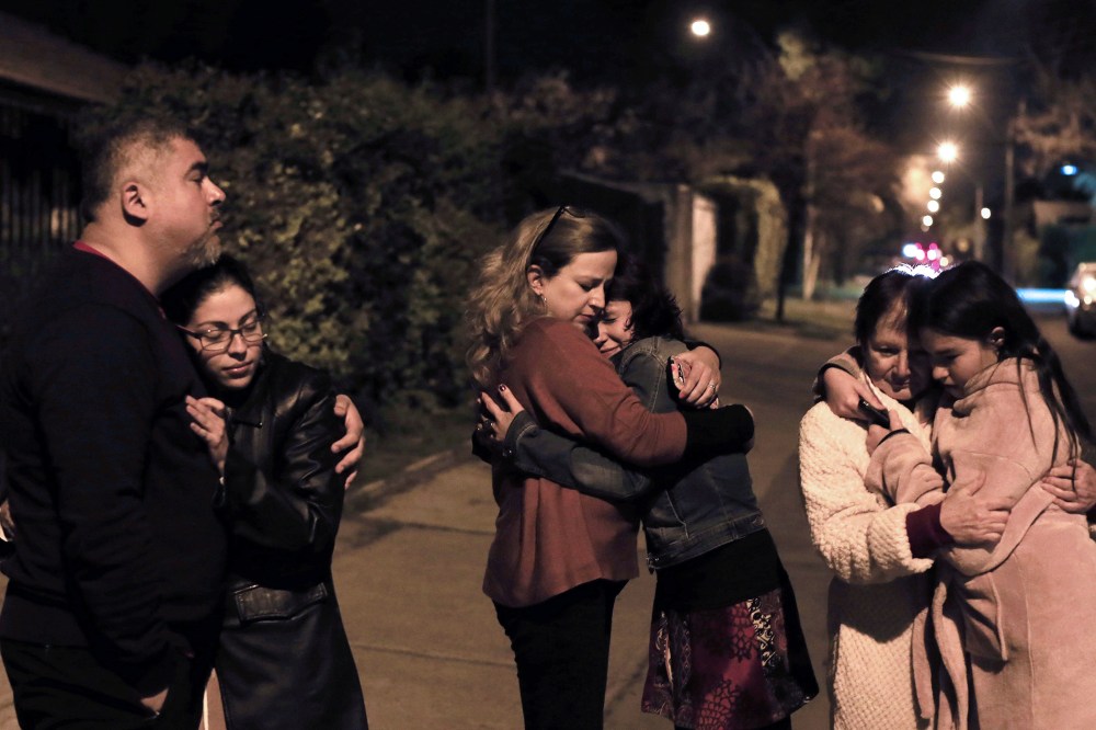 People remain in the street during a strong quake in Santiago on Sept. 16, 2015. (Photo by Alejandro Ruston/AFP/Getty)
