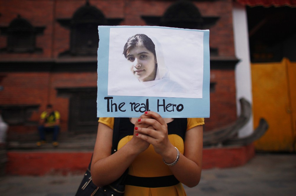 A Nepalese student holds a photo of Pakistani schoolgirl Malala Yousafzai, during a candlelight vigil to express support for her. (AP Photo/Niranjan Shrestha)