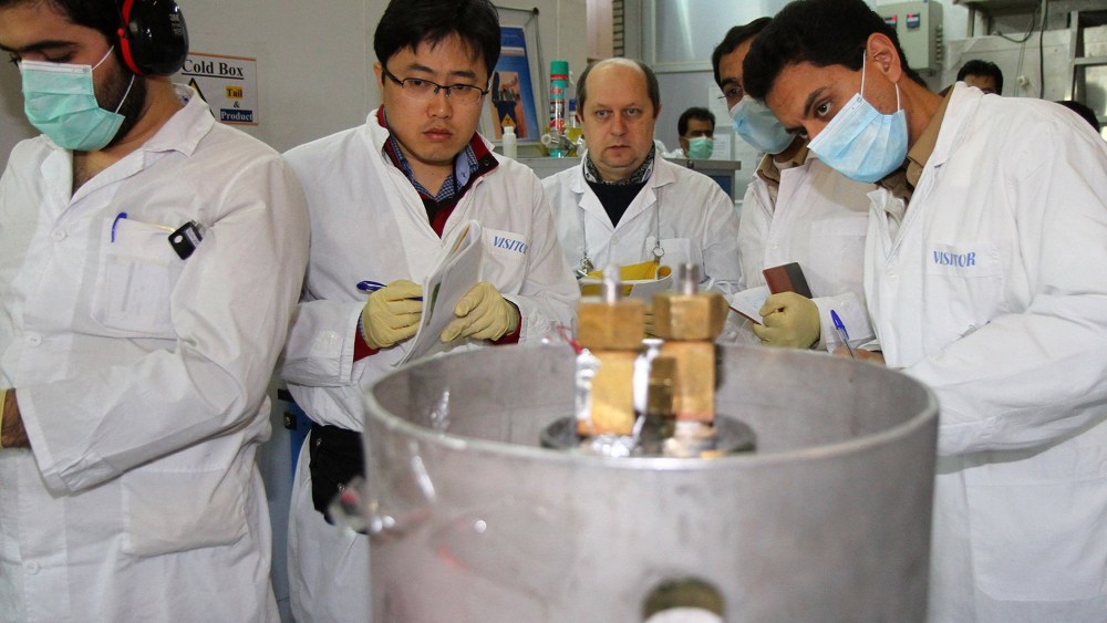Unidentified International Atomic Energy Agency (IAEA) inspectors (2nd-3rd L) and Iranian technicians disconnect the connections between the twin cascades for 20 percent uranium production at nuclear power plant of Natanz, some 300 kilometres south of Teh