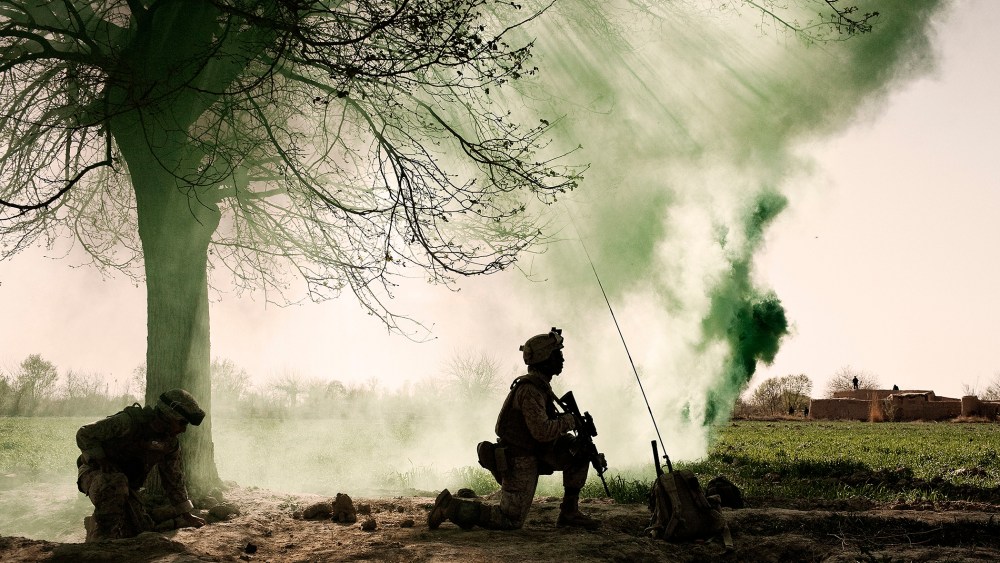US Marines kneel behind a smoke screen at a helicopter landing zone in Marja, Afghanistan, March 2010.