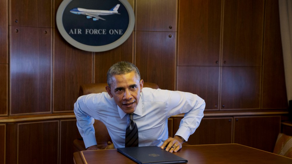 President Barack Obama prepares to walk away from a table, Wednesday, Feb. 19, 2014, in a conference room in flight aboard Air Force One.