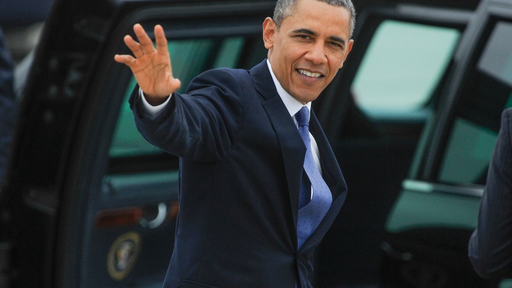 President Barack Obama waves to a crowd gathered at Hartsfield-Jackson International Airport on his way to give the commencement (AP Photo/John Amis)