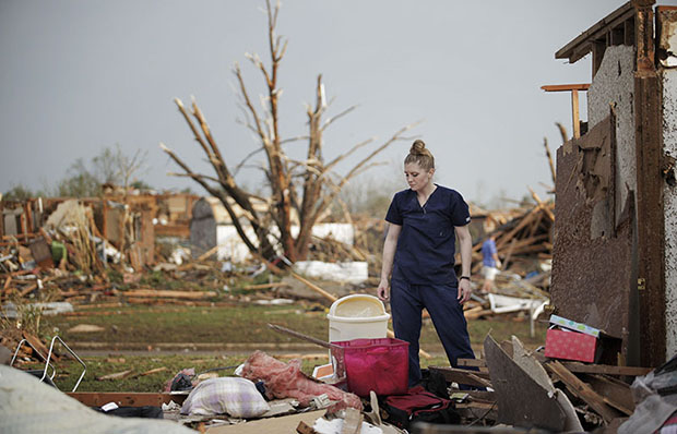 MOORE, OK- MAY 20:  Dana Ulepich looks at the debris from her house destroyed by a powerful tornado ripped through the area on May 20, 2013 in Moore, Oklahoma. The tornado, reported to be at least EF4 strength and two miles wide, touched down in the...