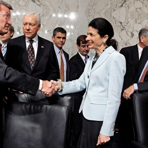 Senate Finance Committee Chairman Max Baucus (D-MT) (L) thanks  Sen. Olympia Snowe (R-ME) for voting in favor of health care reform legislation as committee Republicans Sen. Orrin Hatch (R-UT) and Sen. John Ensign (R-NV) watch, on Capitol Hill October...