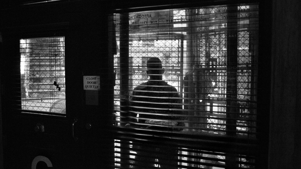 Views through the fenced-in guard post into the common area of a cell block in Camp 6 of Guantanamo Bay in 2012. (Photo by Paolo Pellegrin/Magnum Photos)