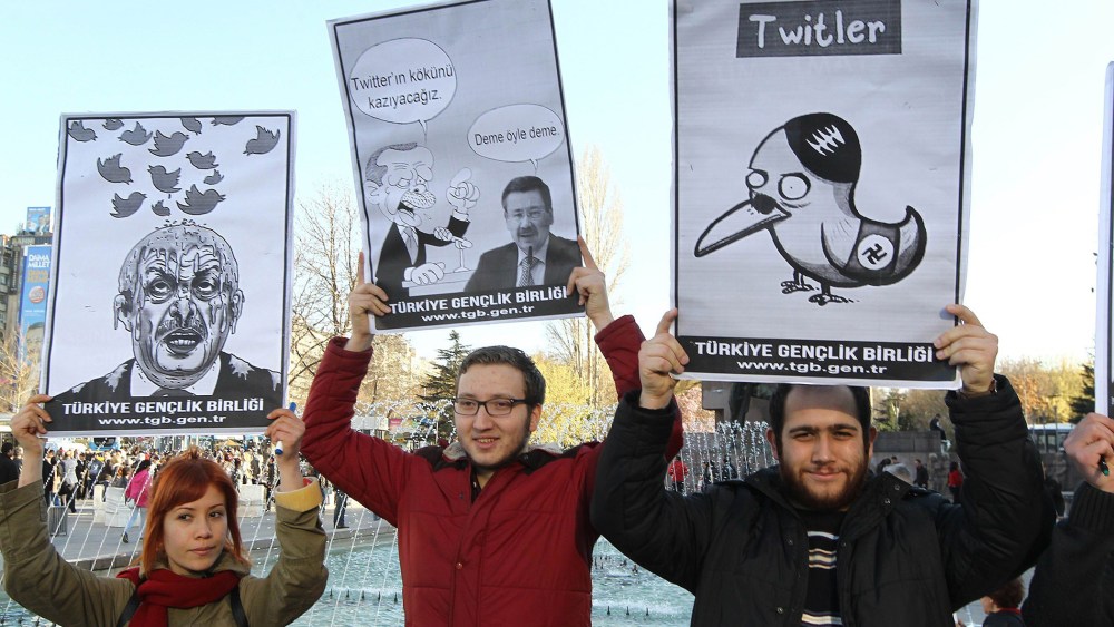 People hold placards as they protest against Turkey's Prime Minister Tayyip Erdogan after the government blocked access to Twitter in Ankara, on March 21, 2014.